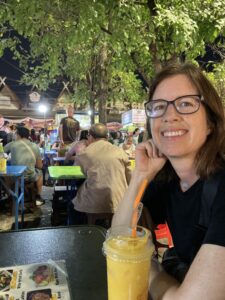 Woman with a mango smoothie in a Thai night market